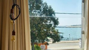 Ett rum med ett stort fönster som vetter mot en strand, en skylt med text och en hängande lampa.