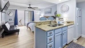 Eine moderne Küche mit Granit Arbeitsplatten, einer integrierten Spüle und einem Kühlschrank.