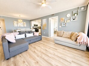A modern living room with a grey sectional sofa, a light grey sofa, and a ceiling fan. - 20th-Floor Oceanfront Condo with Balcony, Pools, Beach Access & Resort Amenities (Ocean City)