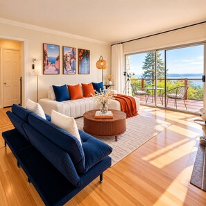 A modern living room with a sofa, coffee table, and artwork on the wall. - Cozy Berkeley Hills Home with Stunning Views (Berkeley)
