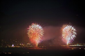 Nachtansicht einer Stadt mit Feuerwerk über dem Wasser.