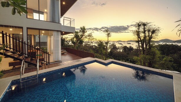 Ein modernes Haus mit Pool, Treppe und Blick aufs Meer.