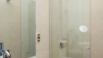 A bathroom with a glass-enclosed shower, a white sink, and a toilet.