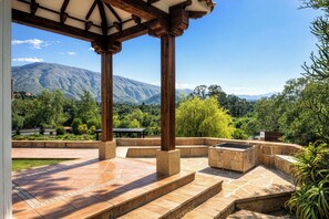 Un patio couvert avec des marches en pierre et une vue sur les montagnes.