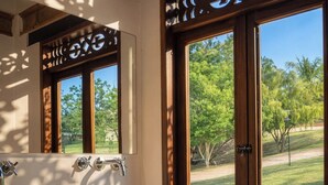 Un baño con un ventanal grande, un lavabo y un espejo.