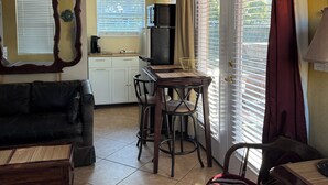 A compact living space with a kitchenette, a dining area, and a seating area with a sofa and chairs.