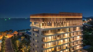 A multi-story hotel with a modern design, featuring balconies and a view of the sea. - Mercure Rayong Lomtalay Villas and Resort (Klaeng)
