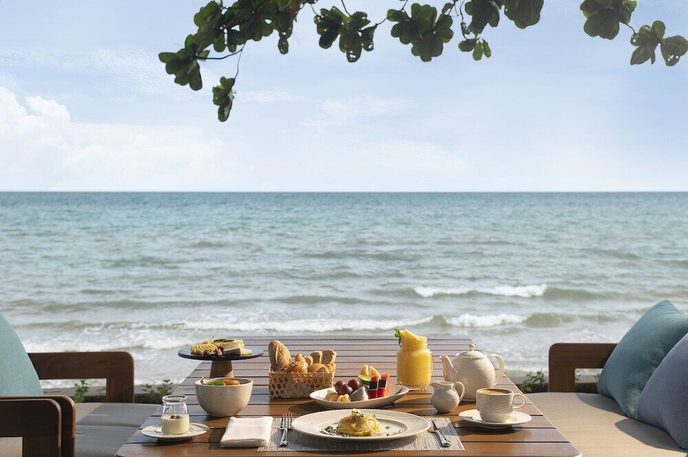 A table set for breakfast with a view of the ocean.