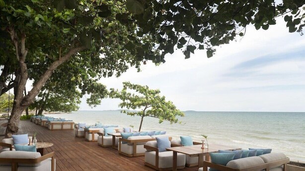 A wooden deck with outdoor seating, overlooking a body of water. - Mercure Rayong Lomtalay Villas and Resort (Klaeng)