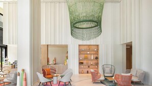 A spacious lobby with modern furniture, a reception desk, and a unique green hanging light fixture. - Mercure Rayong Lomtalay Villas and Resort (Klaeng)