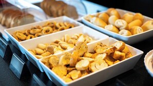 Un buffet con diversi cibi, tra cui pane, pasticcini e altre preparazioni da forno.