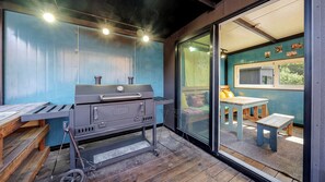 A modern outdoor kitchen with a built-in grill, a wooden table, and a bench. - Gapyeong Ruba Pension (Gapyeong)