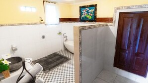 Un baño con bañera, inodoro y zona de ducha.