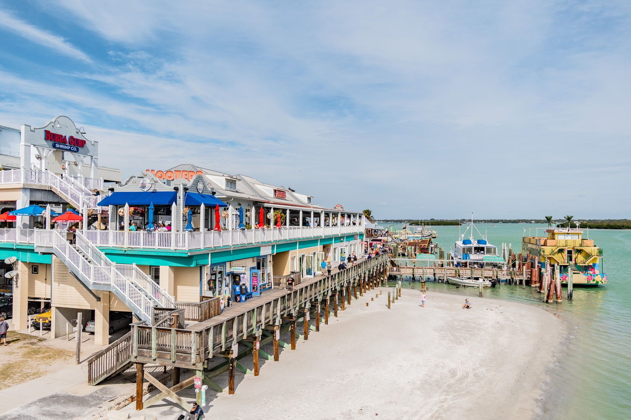 Un restaurant situé au bord de l’eau, avec une terrasse et une jetée qui s’avance dans l’eau.
