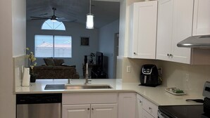 A modern kitchen with white cabinets, a dishwasher, a stove, and a ceiling fan. - Newly Remodeled Mountain Escape Near Casino + Pool Table + Putting Green (Rio Rancho)