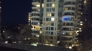 Ein Hochhaus mit mehreren Balkonen und beleuchteten Fenstern.