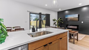 Una cocina moderna con una isla grande, armarios de madera y un lavavajillas empotrado.
