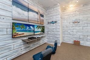 Une pièce avec un mur en bois, un téléviseur à écran plat, un panier de basket fixé au mur et un panier en osier.