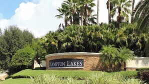 A landscaped area with a sign reading 'Hampton Lakes.' - Villa Minutes From Disney 4bd 3bt Private Pool & Games 4 Bedroom Home (Davenport)