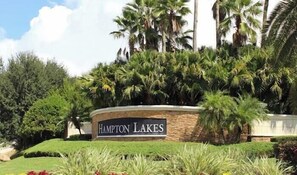 A landscaped area with a sign reading 'Hampton Lakes.' - Villa Minutes From Disney 4bd 3bt Private Pool & Games 4 Bedroom Home (Davenport)
