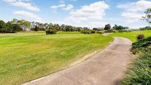 A golf course with a concrete pathway curving through the grass. - 3bd Villa With Private Pool & Golf Walmart 2 Min 3 Bedroom Home (Haines City)