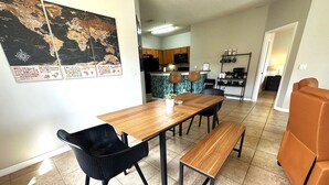 A dining area with a wooden table, black chairs, and a bench.