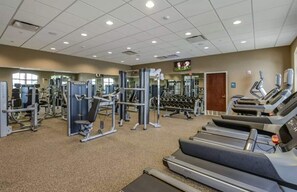 A gym with various exercise equipment including treadmills, weight machines, and free weights. - Villa Near Disney Themed Luxury 5bd With Pool 5 Bedroom Home (Kissimmee)