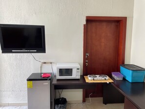 A room with a television, a microwave, a gas stove, and a refrigerator. - Loft 2 with 2 beds near Fundidora and Cintermex (Monterrey)