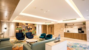 En moderne lobby med siddepladser, reception og kaffestation.