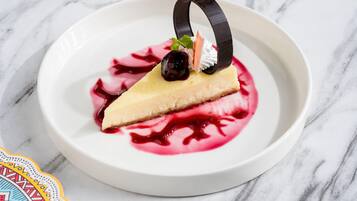 A dessert on a white plate with a decorative ring and a berry garnish.