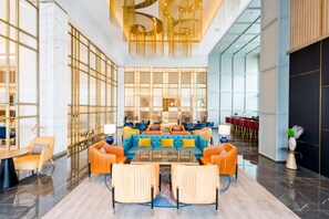 A spacious lobby with a central seating area, a bar, and a dining area. - Holiday Inn Lucknow Airport (Lucknow)