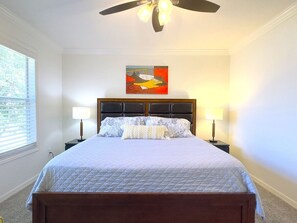 A bedroom with a bed, two bedside lamps, a ceiling fan, and a painting on the wall. - Modern 4br Home In Regal Palms Resort Near Disney 4 Bedroom Townhouse (Davenport)