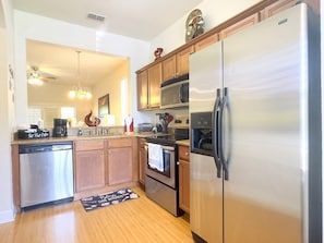 A kitchen with a stainless steel refrigerator, oven, and dishwasher. - 4br Resort Home With Pool And Lazy River Sleeps 10 4 Bedroom Townhouse (Davenport)