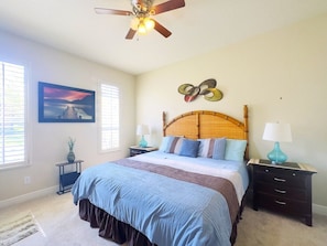 A bedroom with a bed, two nightstands, a ceiling fan, a wall-mounted artwork, and a window with blinds. - 4br Resort Home With Pool And Lazy River Sleeps 10 4 Bedroom Townhouse (Davenport)