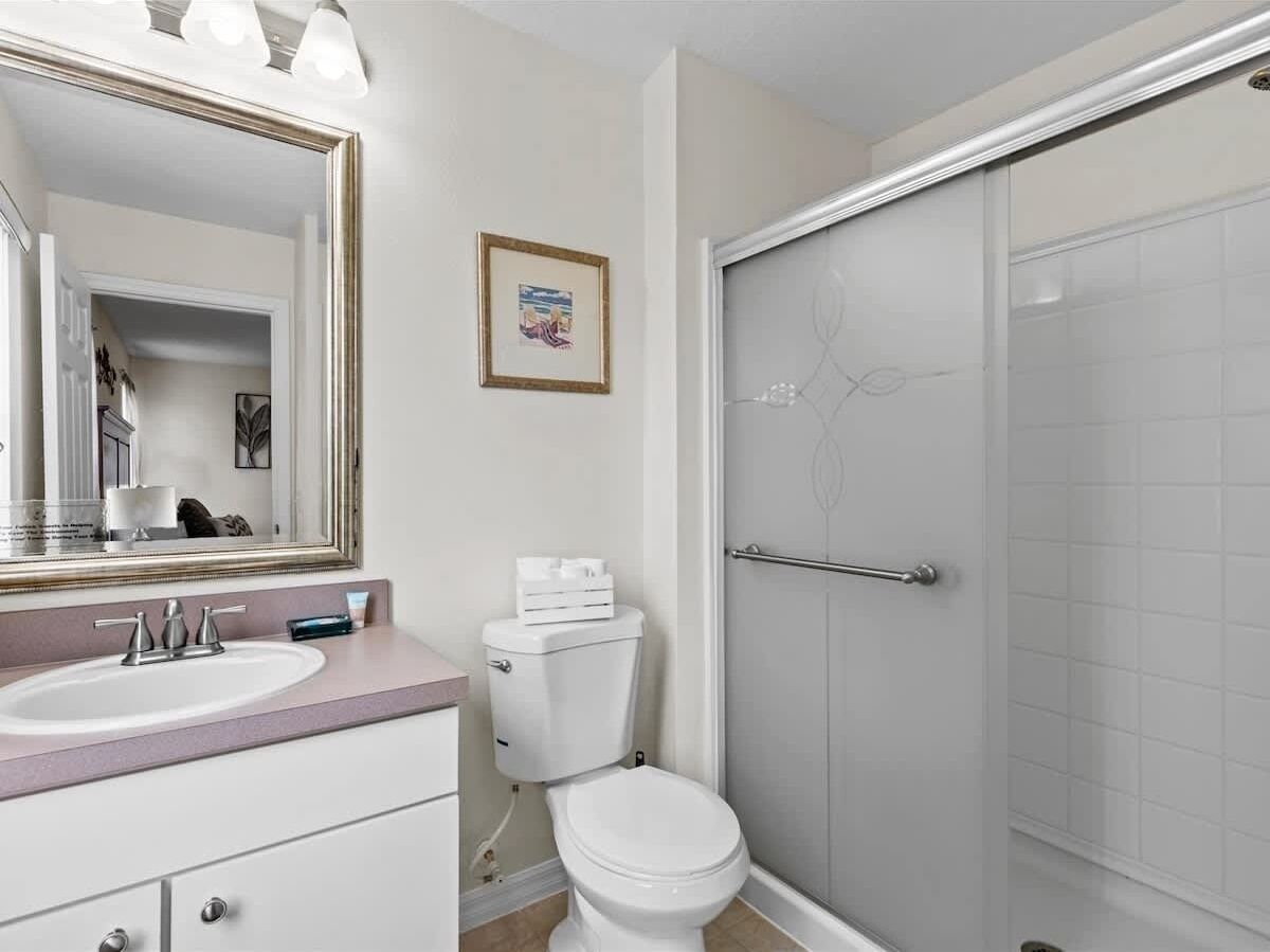 A bathroom with a sink, toilet, and shower.
