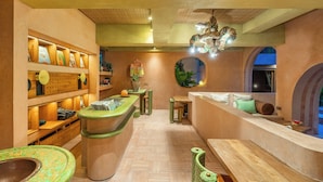 A spa area with wooden benches, a reception desk, and shelves with framed pictures. - Moon Gang Ubud (Ubud)