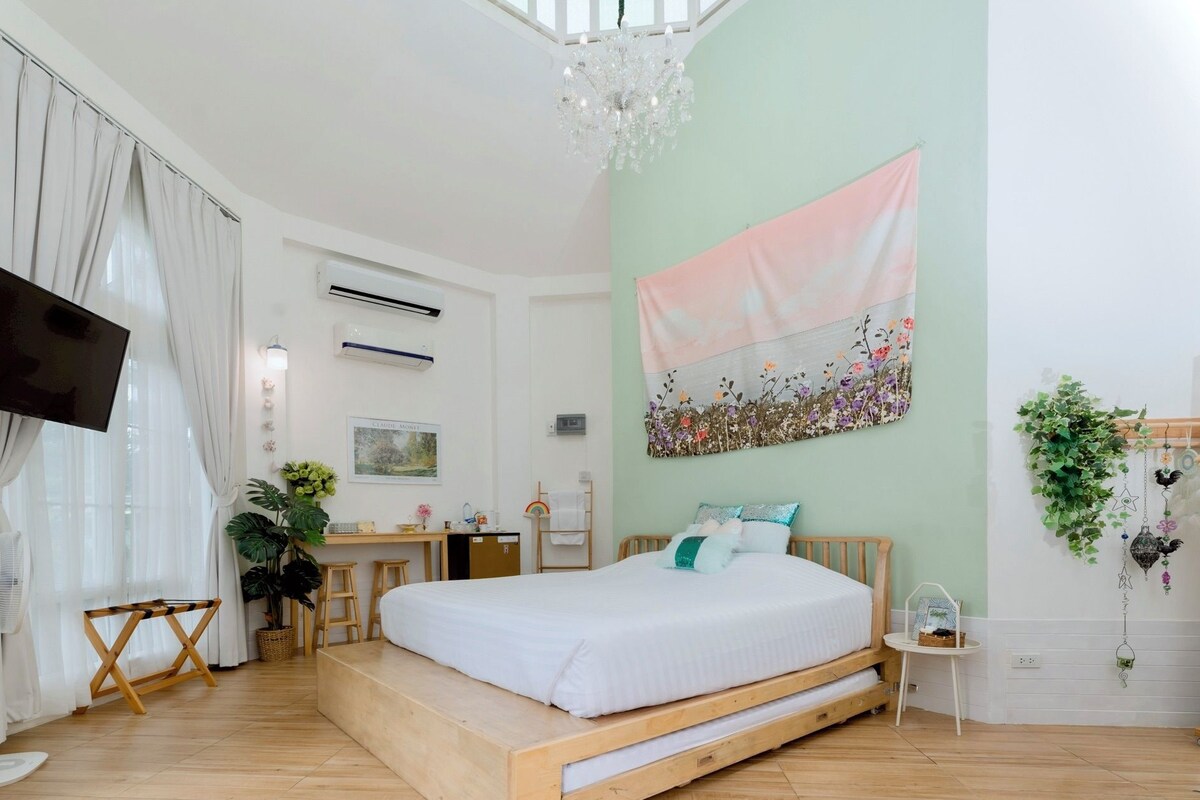 Ein Schlafzimmer mit Bett, Schreibtisch, Stuhl, Fernseher und einer Wandklimaanlage.