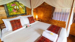 A room with a bed, a nightstand, a painting, and a window with curtains. - Room-jungle Breeze Hideout (Ubud)