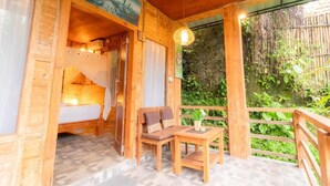 A wooden cabin with a bed, a table, and a bench. - Room-jungle Breeze Hideout (Ubud)