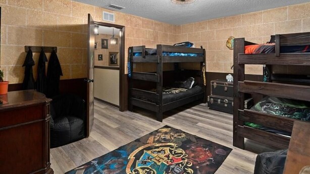 A room with bunk beds, a desk, a chair, and a rug with a fantasy design. - Fully Themed Harry Potter Getaway Close Disney 3 Bedroom Townhouse (Davenport)