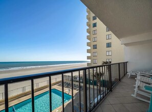 Ein Balkon mit Blick auf Strand und Pool.