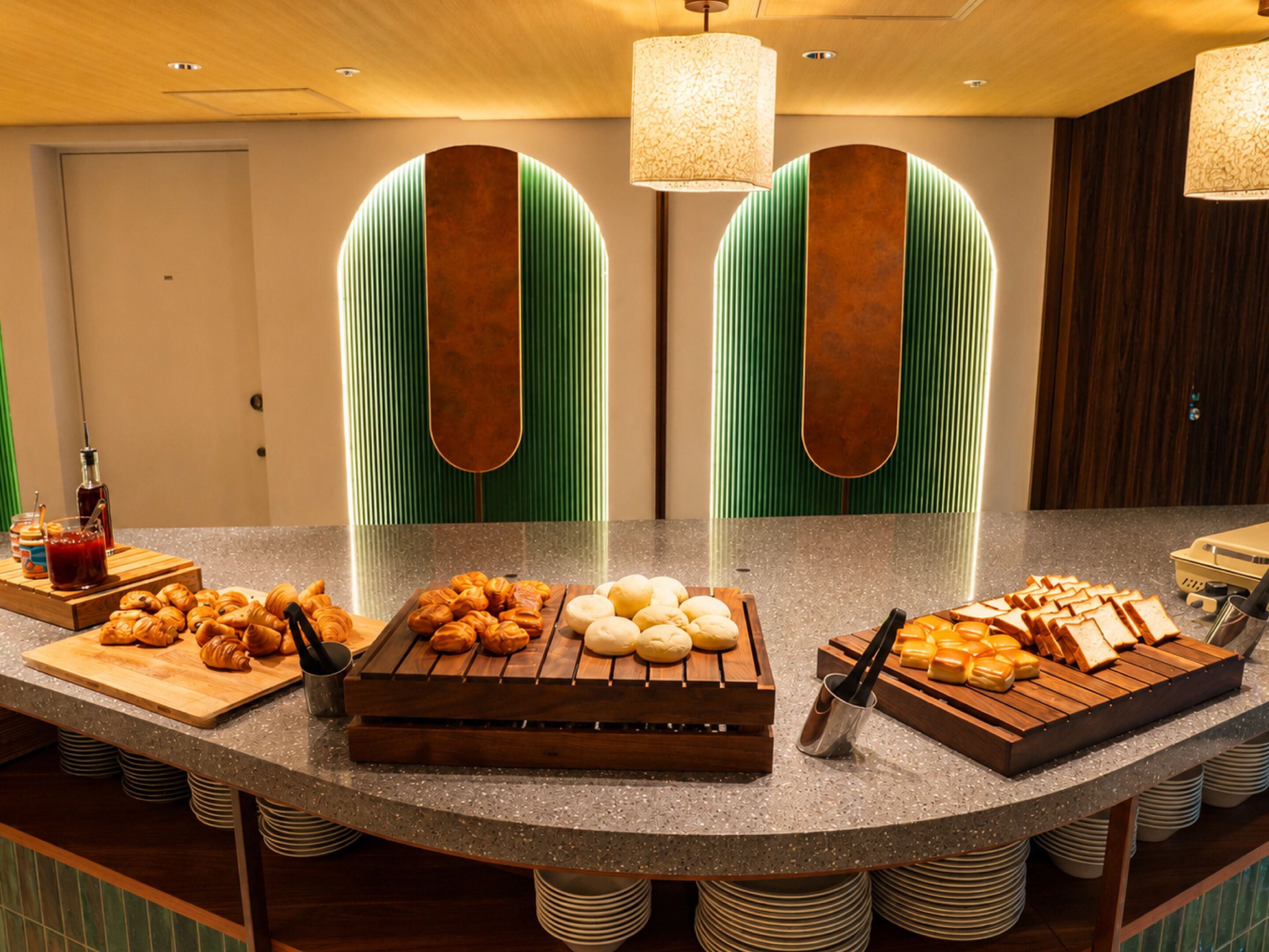 Buffet de café da manhã com pães, queijos e pastelaria.