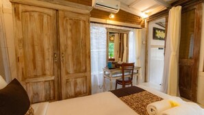 A bedroom with a large bed, wooden wardrobe, and a desk with a chair. - Room-romantic Jungle Nest (Ubud)