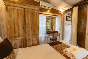 A bedroom with a large bed, wooden wardrobe, and a desk with a chair. - Room-romantic Jungle Nest (Ubud)