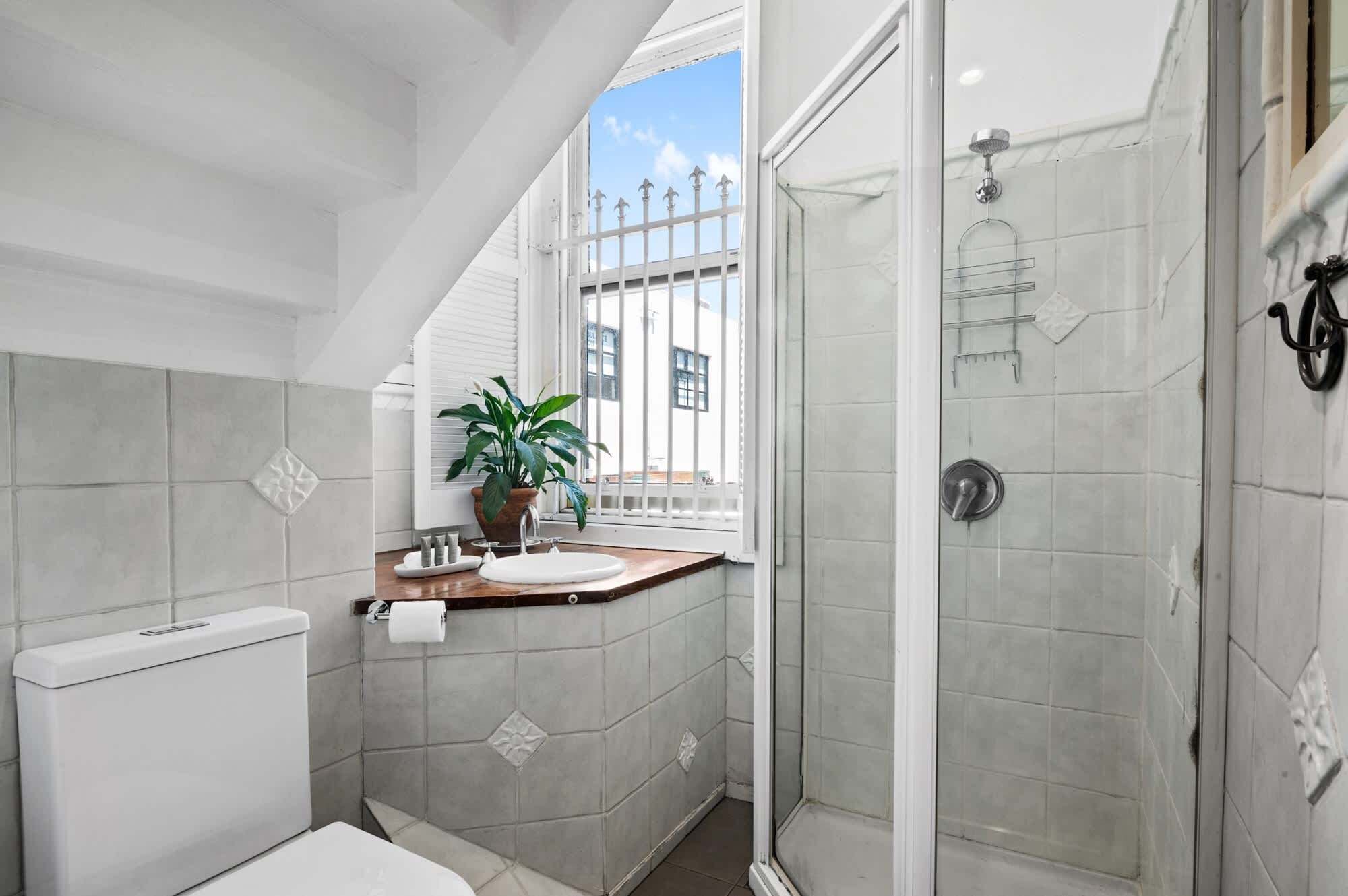 A bathroom with a toilet, sink, and shower.
