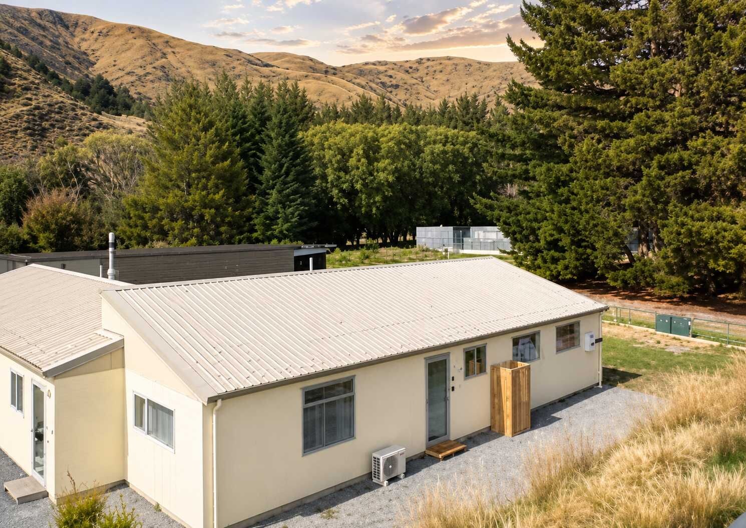 A two-story building with a flat roof, a small porch, and a window.