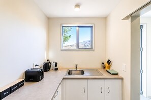 A compact kitchen with a window, a sink, and a countertop.