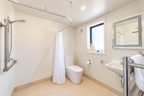 Ein modernes Badezimmer mit Dusche, Toilette, Waschbecken und einem Fenster für natürliches Licht.