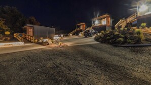 Un bâtiment moderne avec un escalier, une voiture garée devant et une entrée bien éclairée.