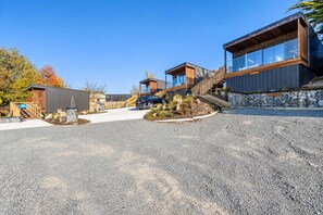 Ein modernes Gebäude mit einer Stein-Fassade, einem Holzdeck und blauem Himmel.